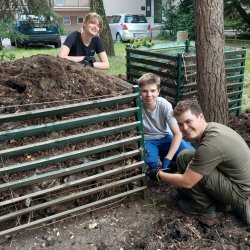 Dobrovoľníci SPŠE pri rozoberaní komunitného kompostoviska